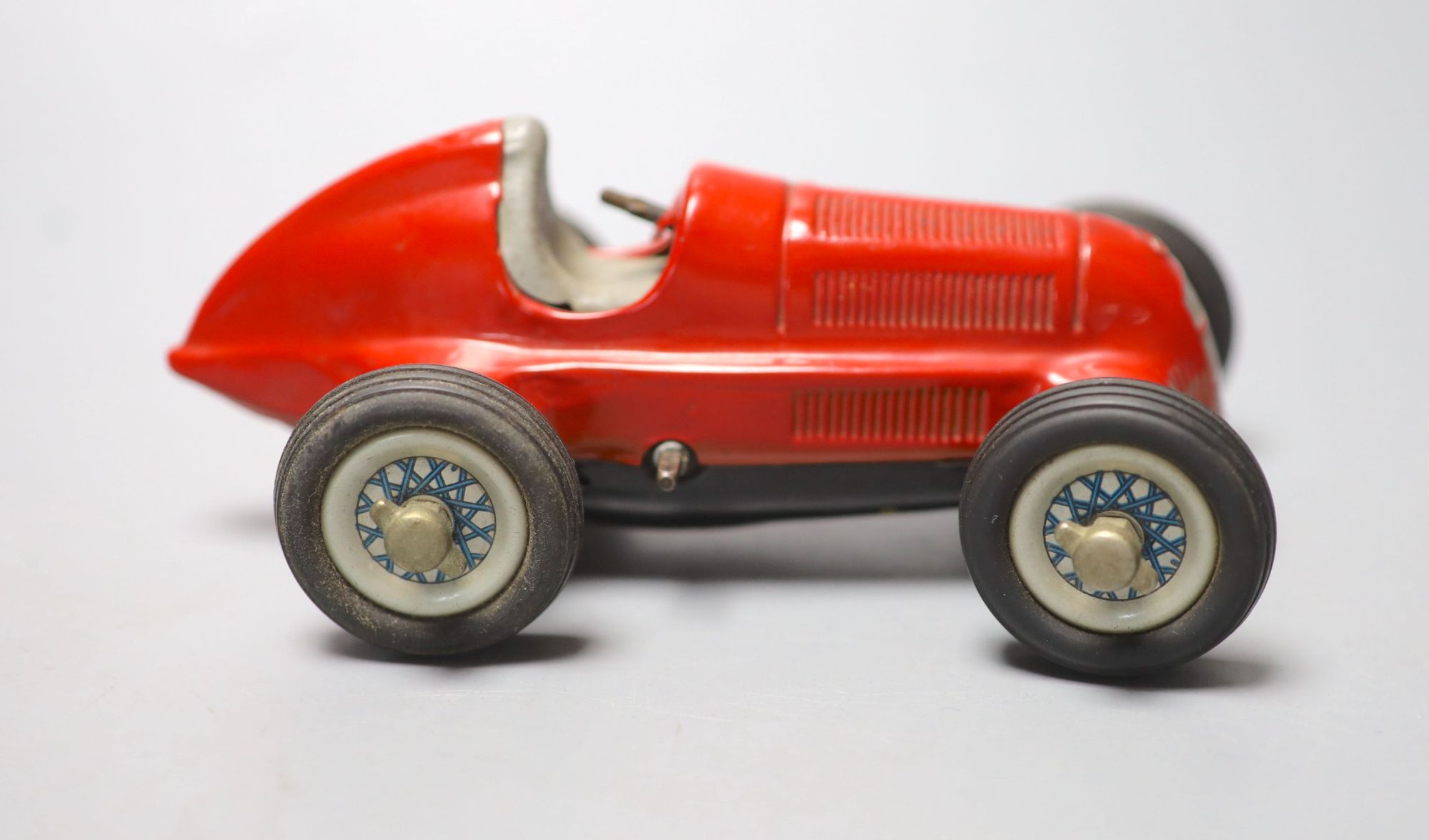 A Schuco Studio 1050 clockwork Mercedes racing car in red, length 14cm